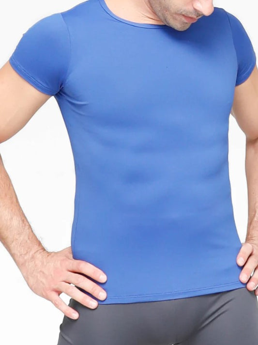 Dancer is wearing a blue short-sleeve snug-fit dance shirt. He has paired it with grey tights and has his hands on his hips.