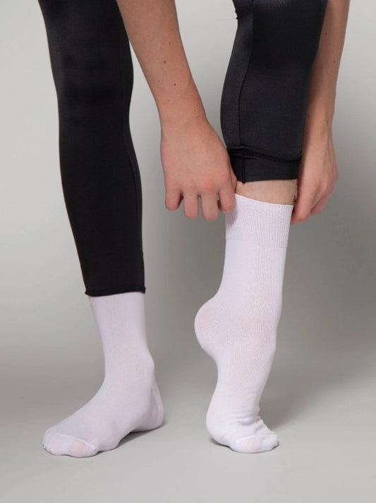 Dancer is wearing a pair of lightweight white dance socks with black leggings.
