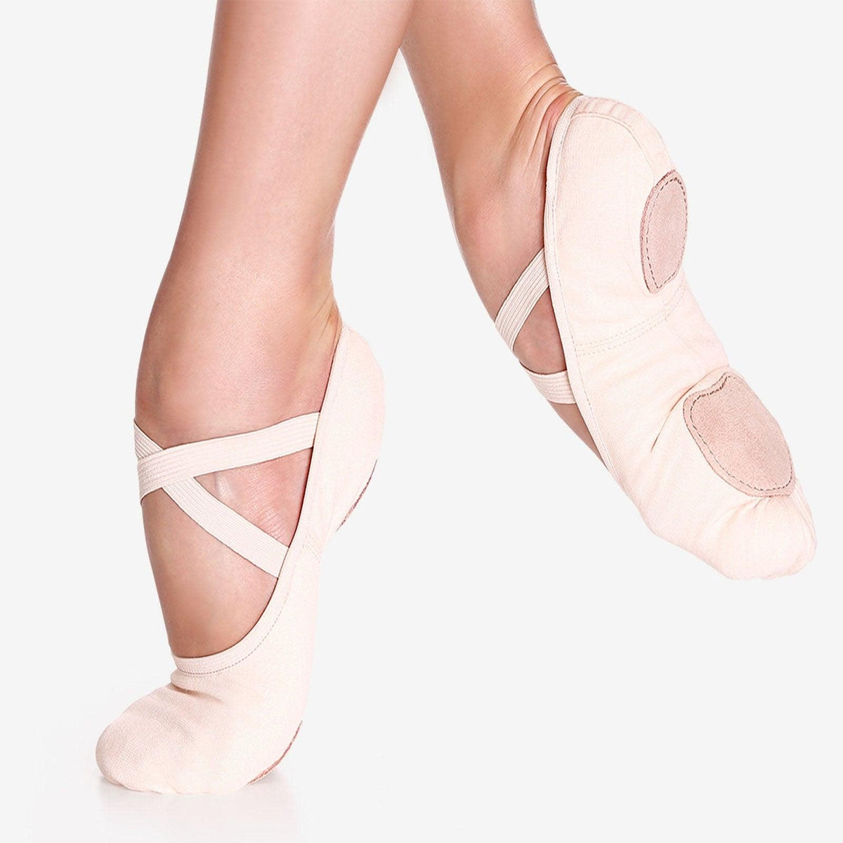 Dancer is wearing a pair of pink canvas ballet shoes. Cross elastic straps come pre-sewn. 