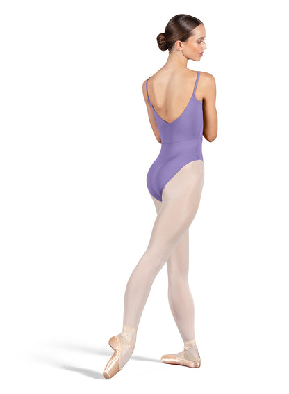 Dancer is wearing a lavender, camisole leotard with a scoop neck and back and bodice seam detail. She has paired the garment with pink tights and pointe shoes. Dancer is standing with her right foot pointed back and is showing a back angle of the leotard.