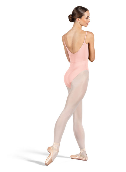 Dancer is wearing a light pink, camisole leotard with a scoop neck and back and bodice seam detail. She has paired the garment with pink tights and pointe shoes. Dancer is standing with her right foot pointed back and is showing a back angle of the leotard.