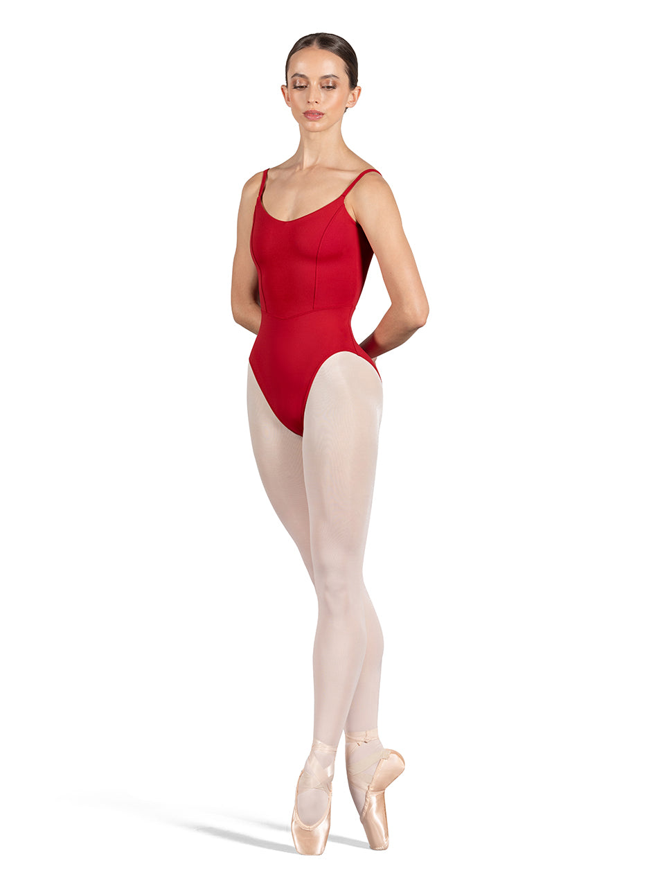 Dancer is wearing a red, camisole leotard with a scoop neck and back and bodice seam detail. She has paired the garment with pink tights and pointe shoes and is balancing in a fourth position releve on pointe with her hands behind her back.