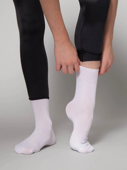 Dancer is wearing a pair of lightweight white dance socks with black leggings.