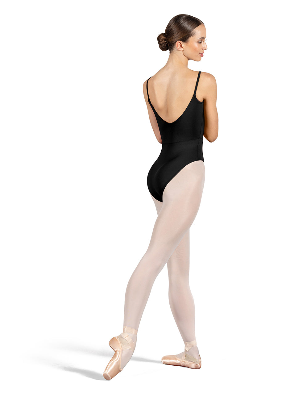 Dancer is wearing a black, camisole leotard with a scoop neck and back and bodice seam detail. She has paired the garment with pink tights and pointe shoes. Dancer is standing with her right foot pointed back and is showing a back angle of the leotard.